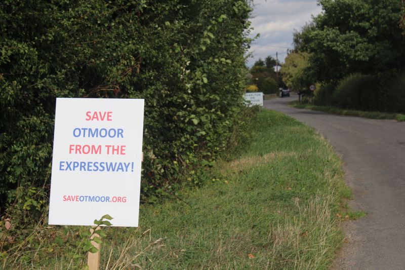 Save Otmoor sign on grass verge along country lane