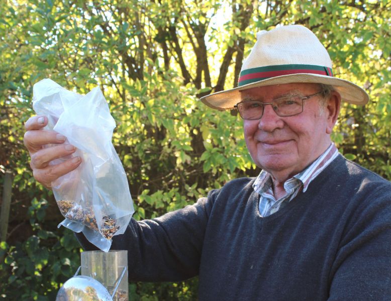 Ray Cobbett filling birdfeeders in his garden in Emsworth