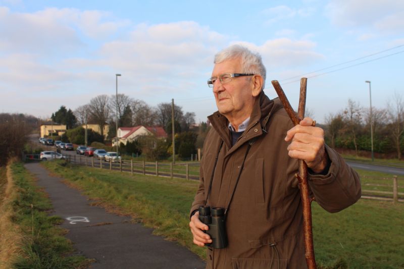 Jim Davies from United Valleys Action Group with binoculars by side of country road