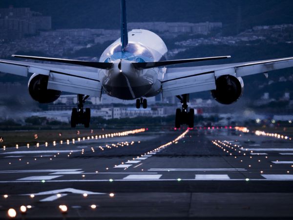 Close-up from rear of passenger jet landing at night.
