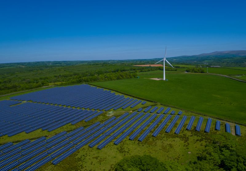 Photo of solar array and wind turbine in countryside