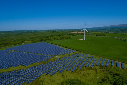 Photo of solar array and wind turbine in countryside
