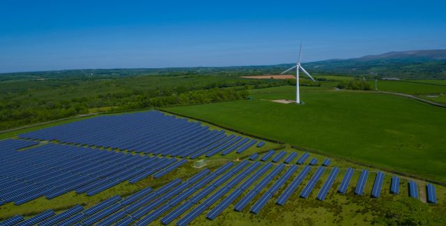 Photo of solar array and wind turbine in countryside
