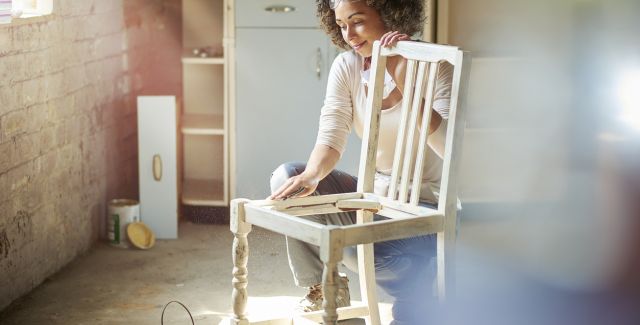 photo of woman sanding wooden chair