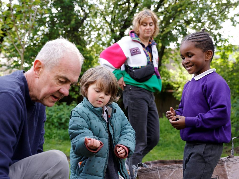 Gardener and two children looking at the ground