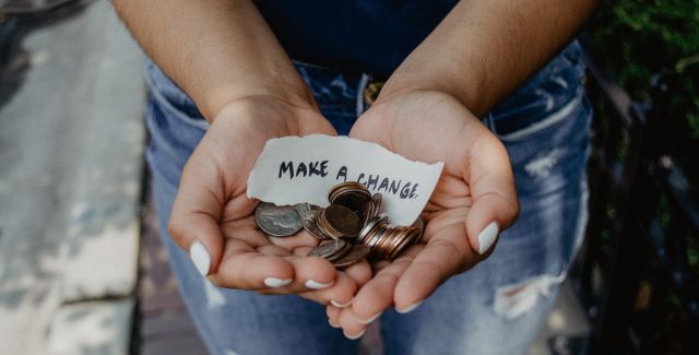 Hands holding money with Make a Change message