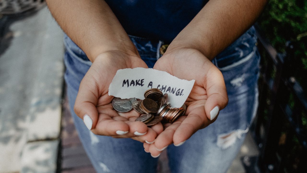 Hands holding money with Make a Change message