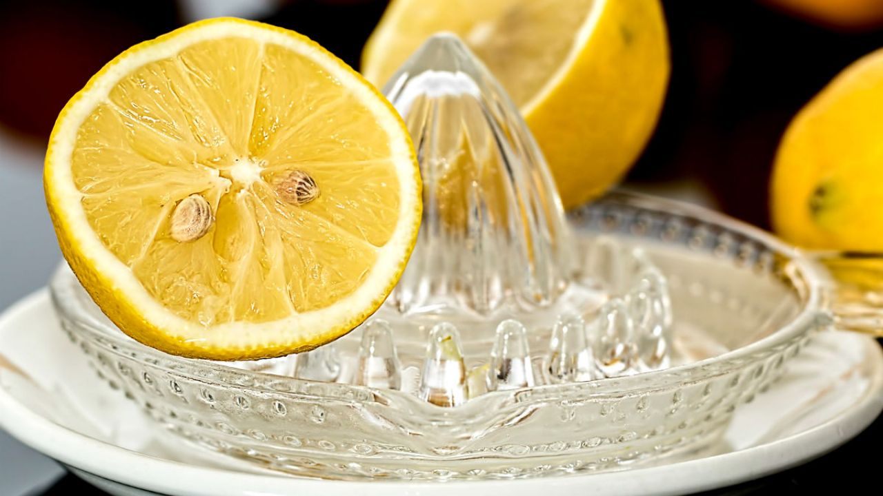 Half a lemon on top of a lemon squeezer
