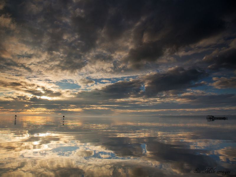 A cloudy blue sky is reflected in Lough Neagh