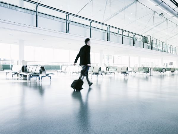 photo of man walking through empty airport terminal