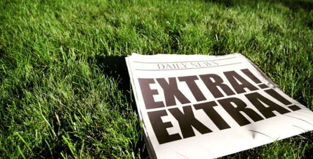 Newspaper with Extra Extra headline laying on a lawn