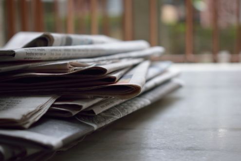 Stack of newspapers on a wooden table