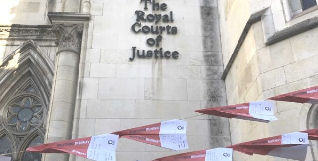 Paper planes displaying messages opposing a third runway at Heathrow outside the Royal Courts of Justice.