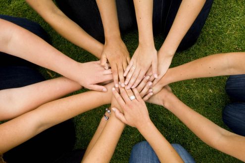 group of people joining hands
