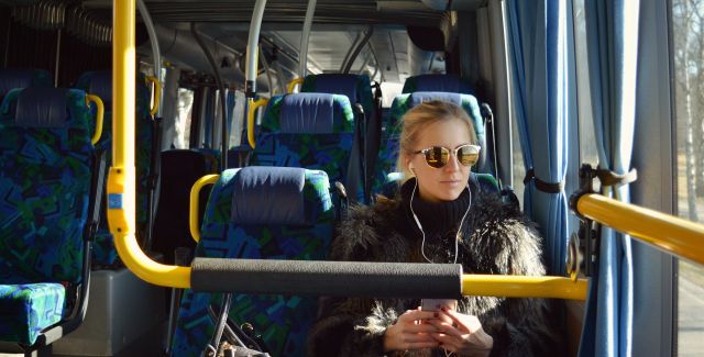 photo of passenger on a bus with earphones and sunglasses