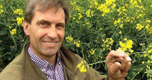 Casually dressed "green" farmer Peter Lundgren with background of yellow flowers.