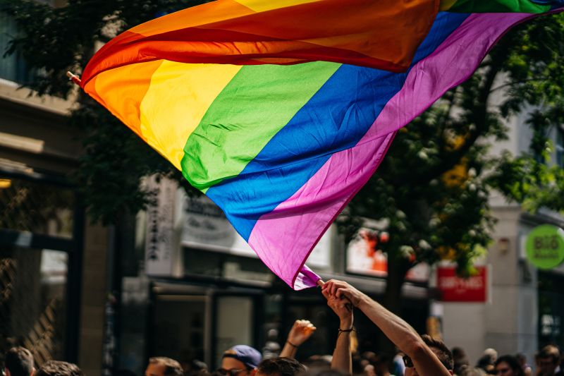 Pride rainbow flag over a crowd of people