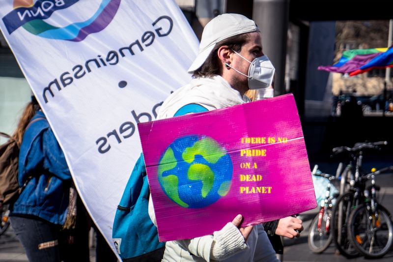A protester holding a placard that reads "There is no Pride on a dead planet"