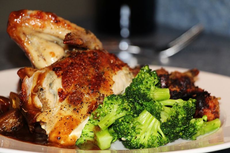Plate of roast chicken, gravy, and broccoli