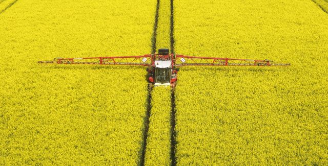 photo of oilseed rape field being sprayed