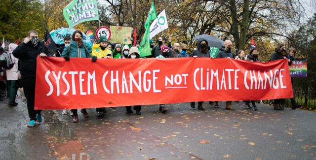 Protesters Carrying Banner That Reads 'System Change Not Climate Change'