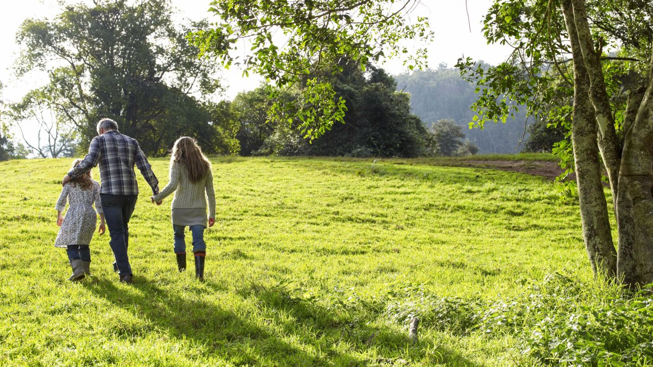 Parent with children walking across field