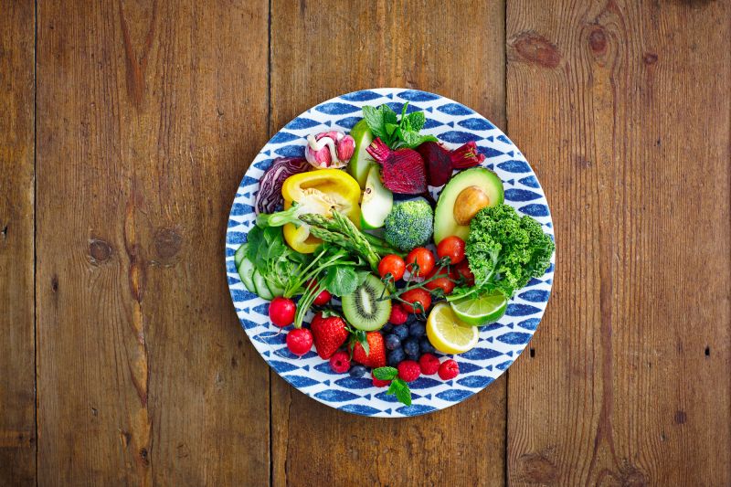 healthy fruits and vegetables salad served on a plate on wooden counter