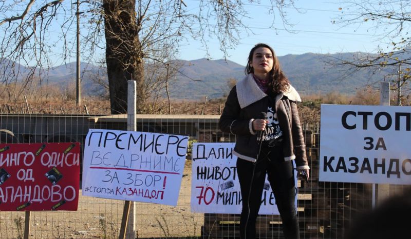 Young Macedonian activist Simona Getova, speaking in front of campaign banners