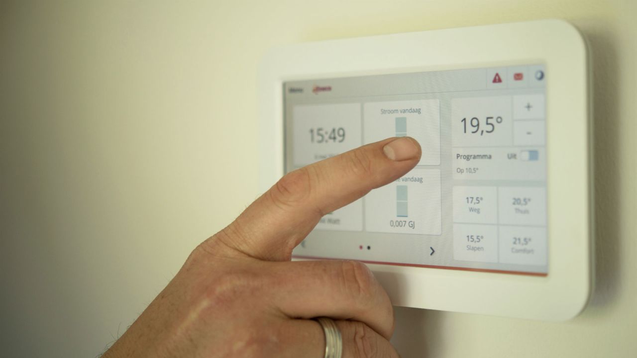A man's finger next to a smart energy meter display panel