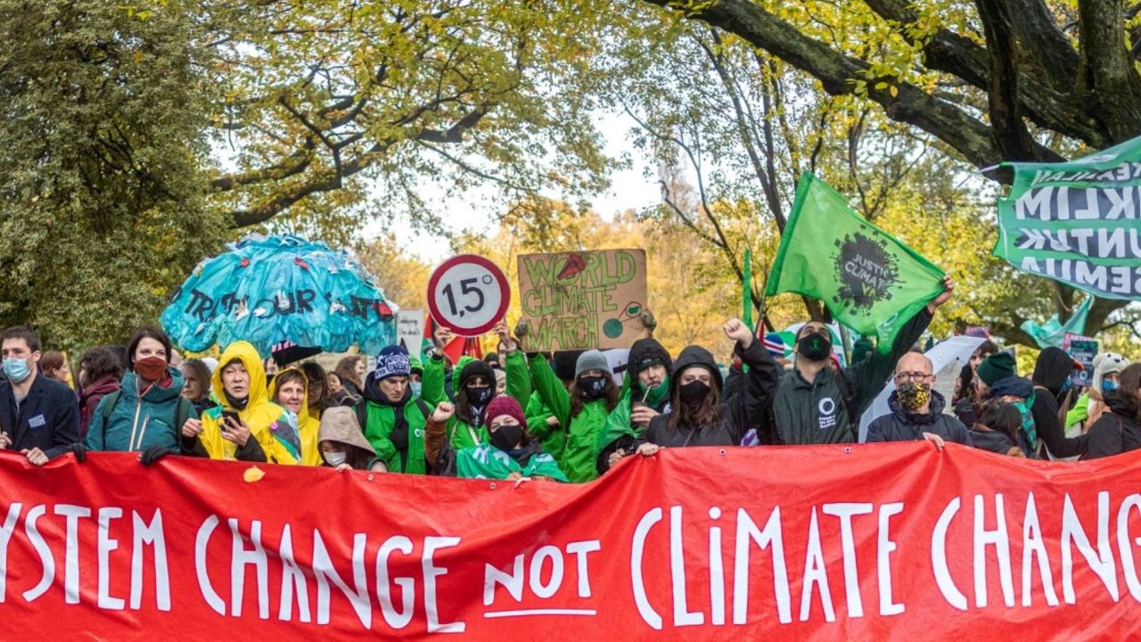 System change not climate change banner being held up by a large group of people