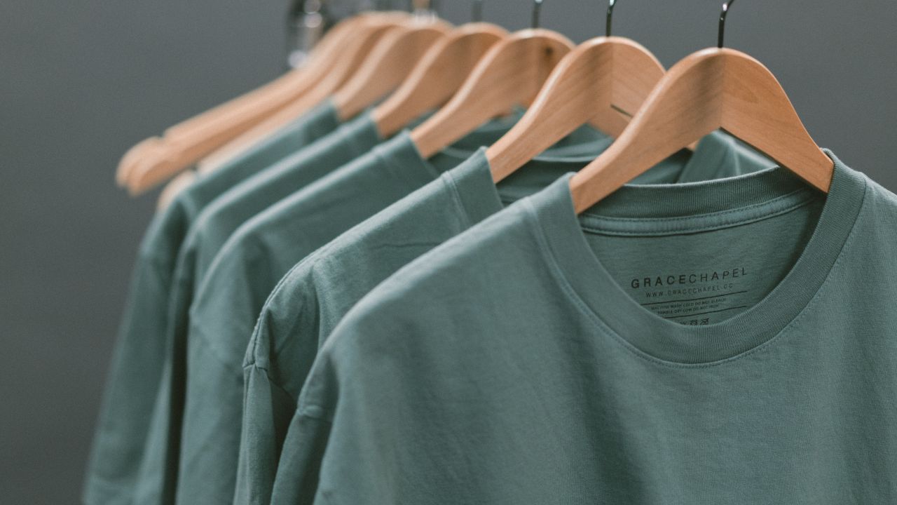 A row of the same teal-coloured t-shirt