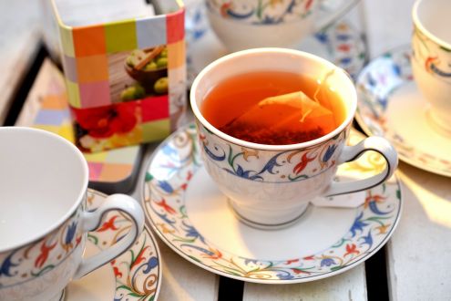 A tea bag steeping in a cup on a saucer