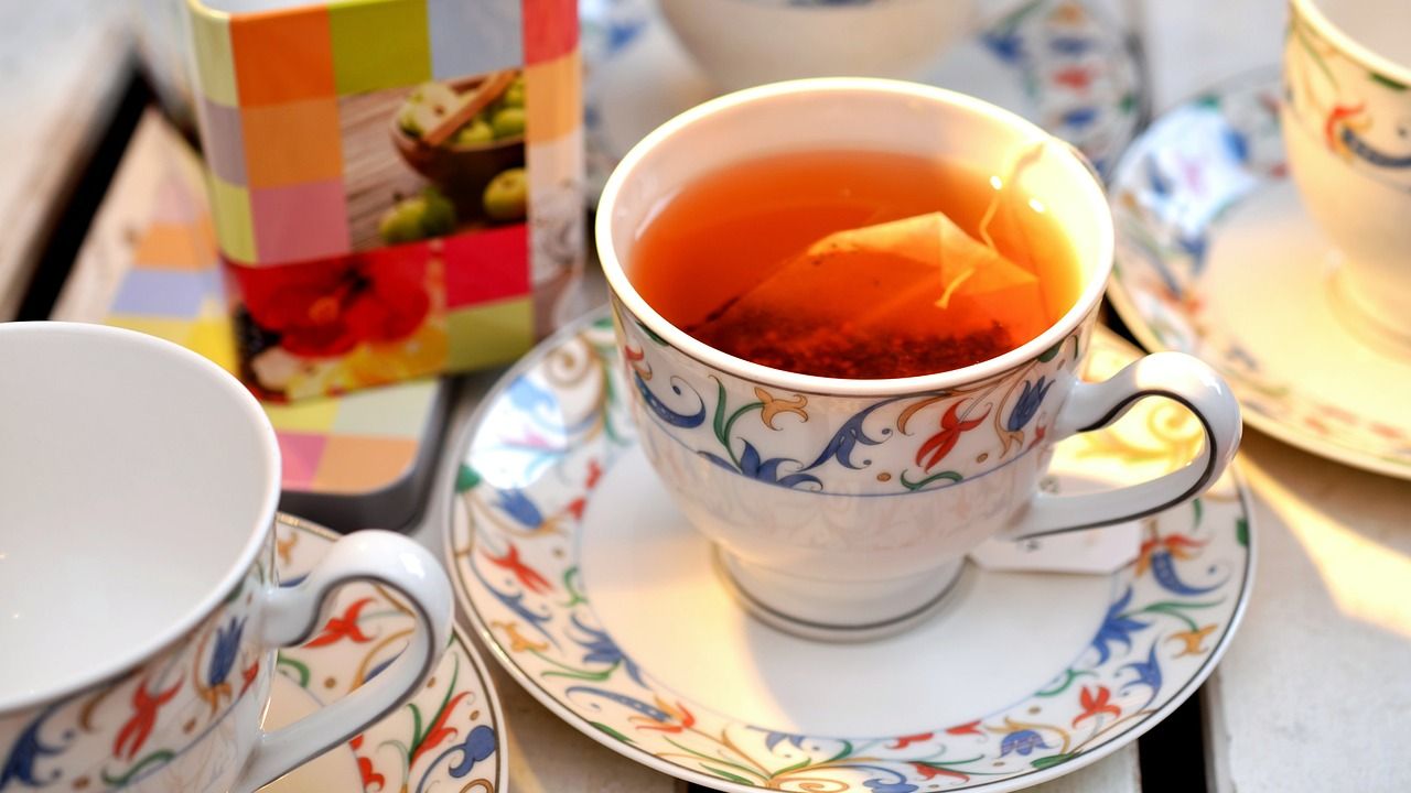A tea bag steeping in a cup on a saucer