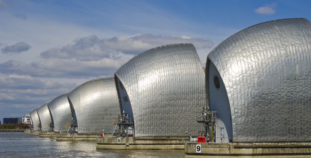 A line of silver flood defence barriers on the River Thames