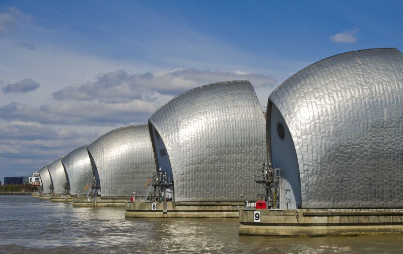 A line of silver flood defence barriers on the River Thames