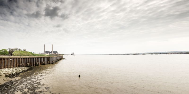 A landscape shot of the River Thames with the Tilbury power station in the distance on the left bank