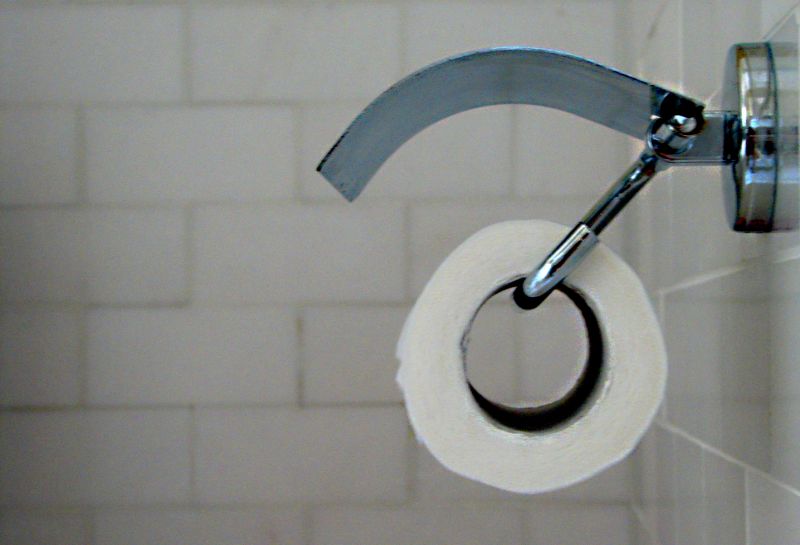 A roll of toilet paper in a holder on a bathroom wall