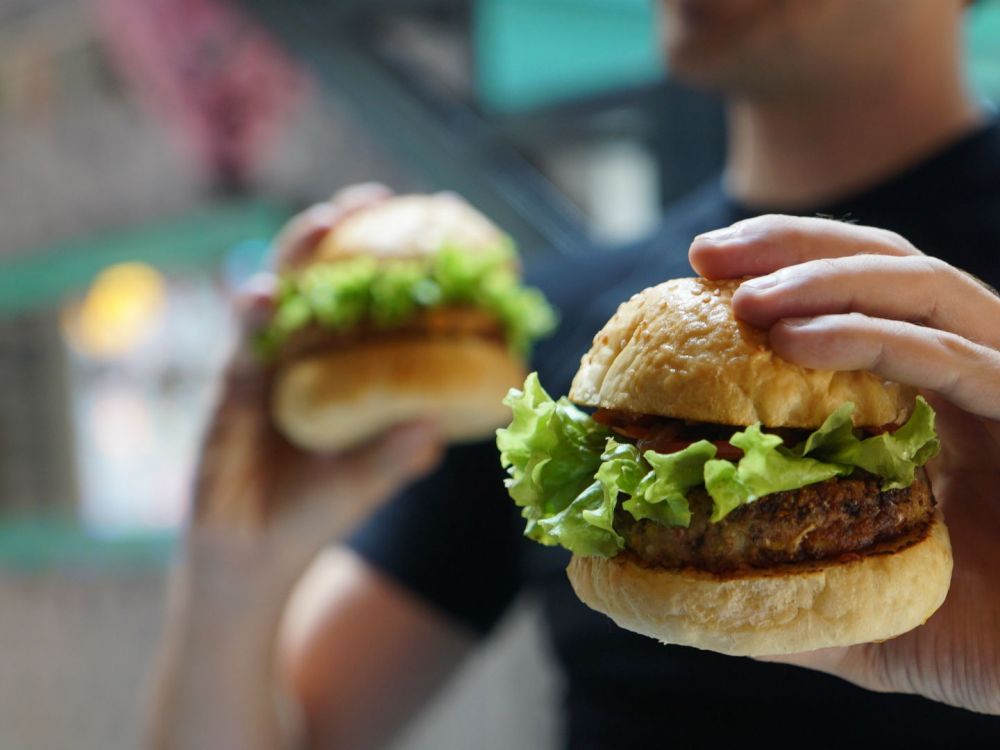 Person holding two vegan burgers