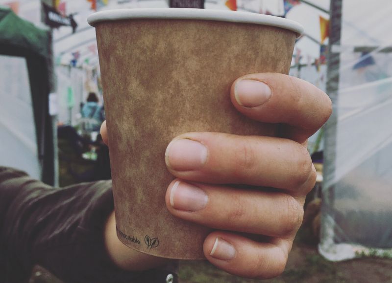 Hand holding Vegware compostable cup