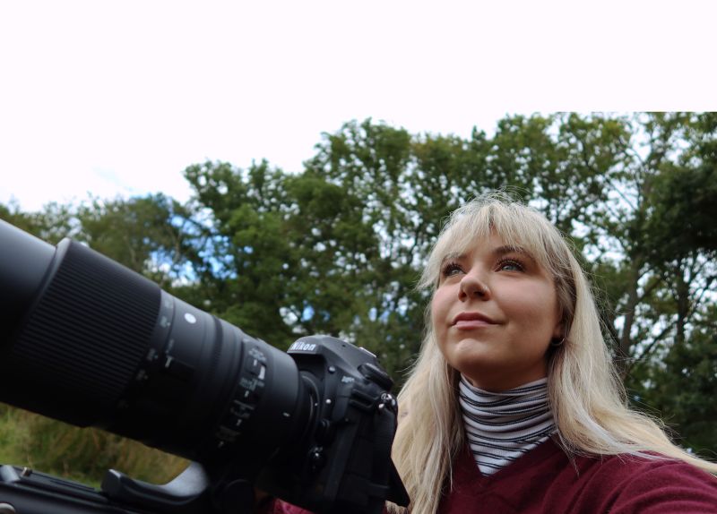A portrait of a woman holding a camera