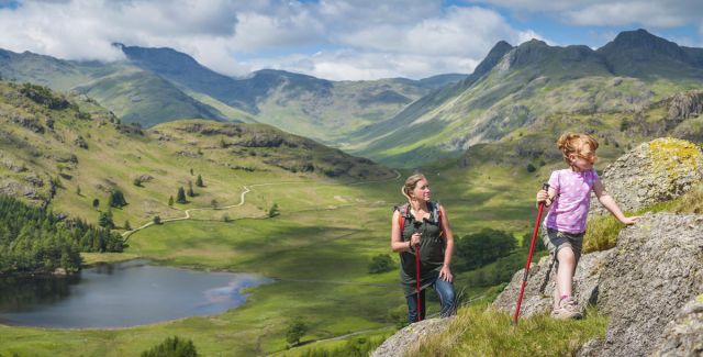 Woman and child hiking in stunning hilly landscape, Lake District National Park