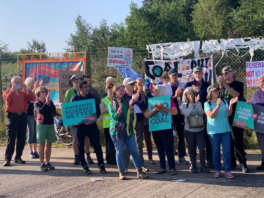 Group of people holding placards protest against proposed new coal mine in Whitehaven