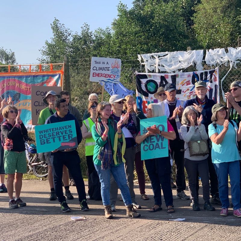 Group of people holding placards protest against proposed new coal mine in Whitehaven