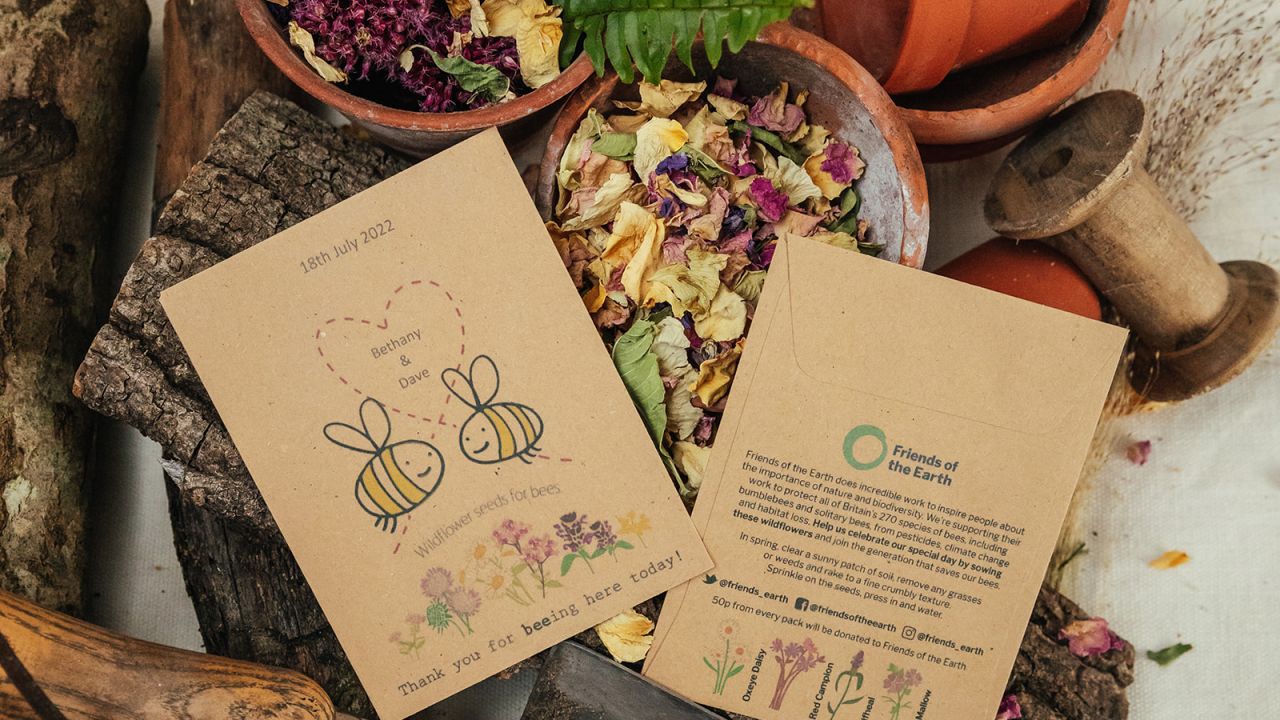 Photo of Friends of the Earth bee cause charity wedding favours set amongst plant pots, dried flowers and trowel