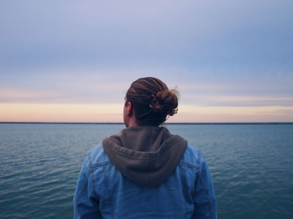 The back of a person looking out at the ocean