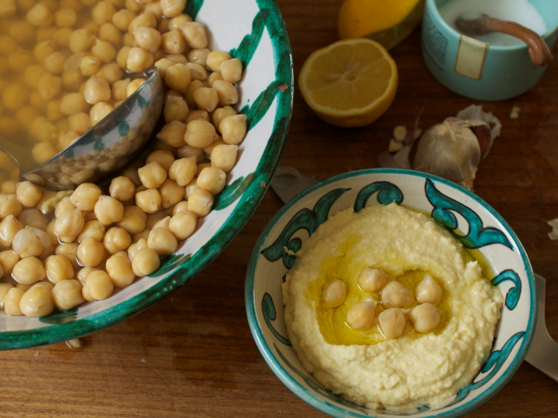 Chickpeas in a bowl alongside a small dish of homemade hummus