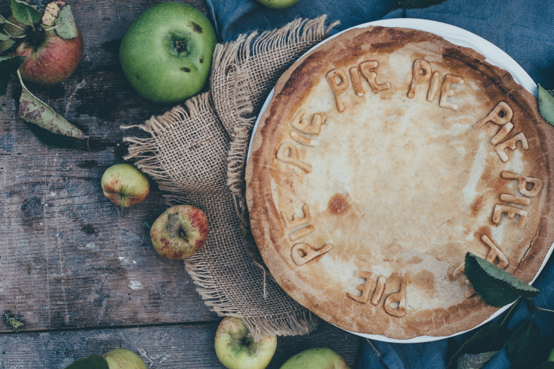 Vegan apple and fig pie made with vegetarian suet pastry with a few apples scattered around