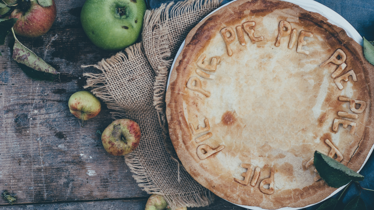 Vegan apple and fig pie made with vegetarian suet pastry with a few apples scattered around