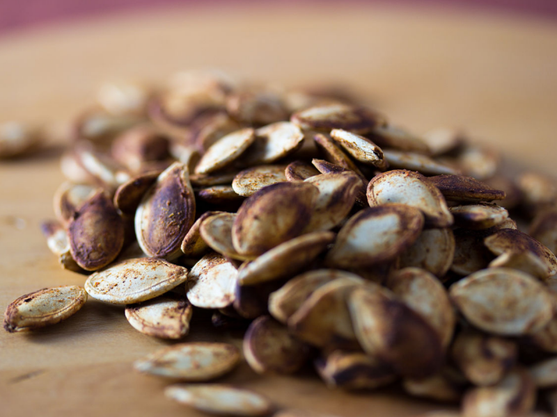 Pile of roasted pumpkin seeds on a chopping board