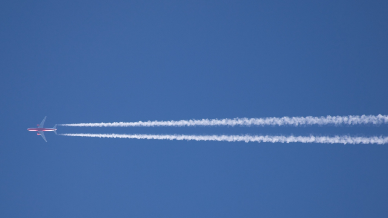 Aeroplane flying across the sky with vapour trail